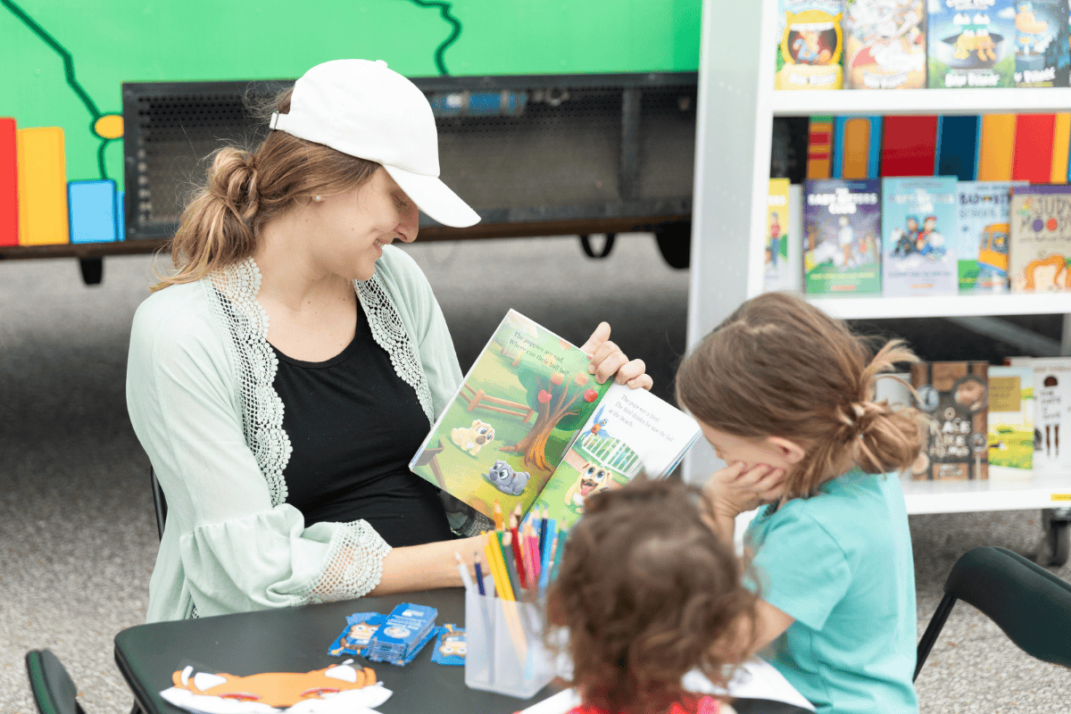 A mother reads a book to her two daughters..