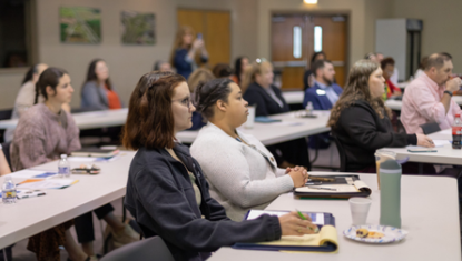 People are sitting and listening to the current forum speaker.